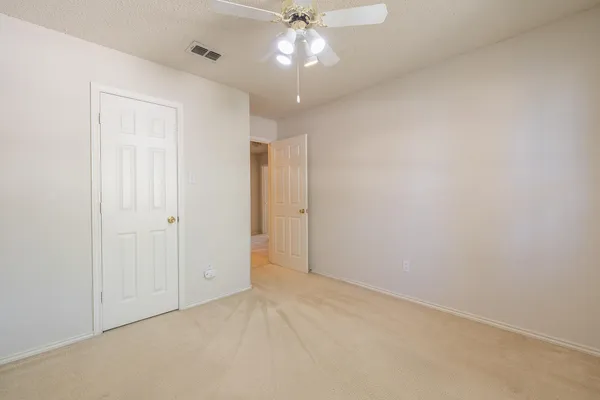 an empty room with a fan and a fan