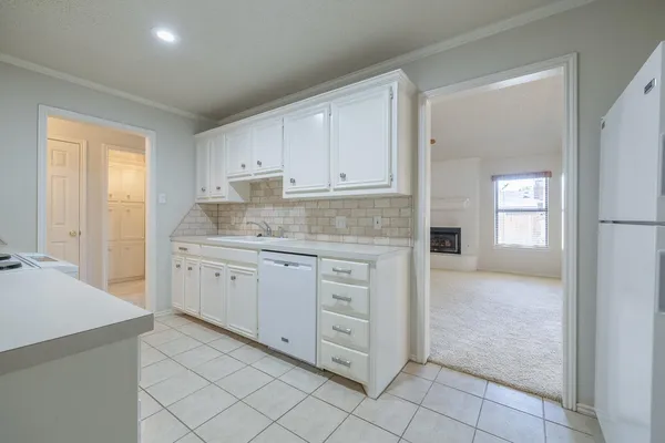 a kitchen with white cabinets and white appliances