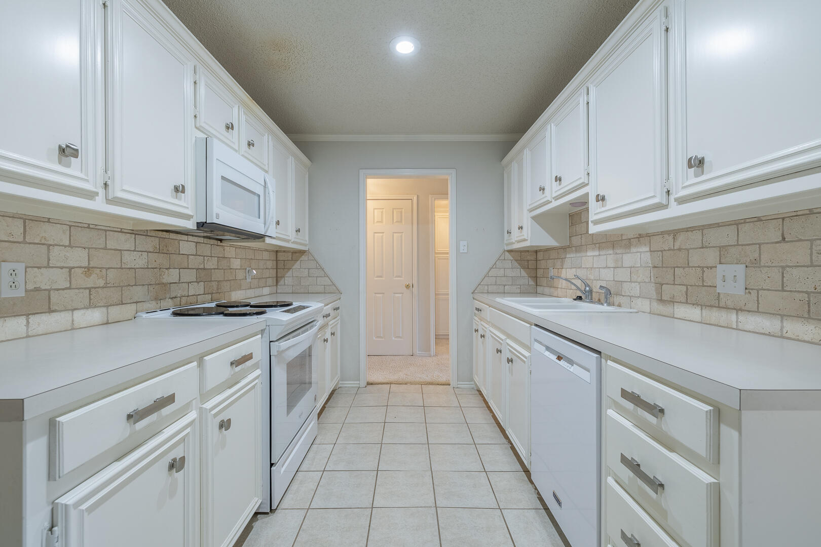 5415 68th Street Lubbock, TX 79424 - Photo 34 of 57 a kitchen with granite countertop white cabinets and stainless steel appliances