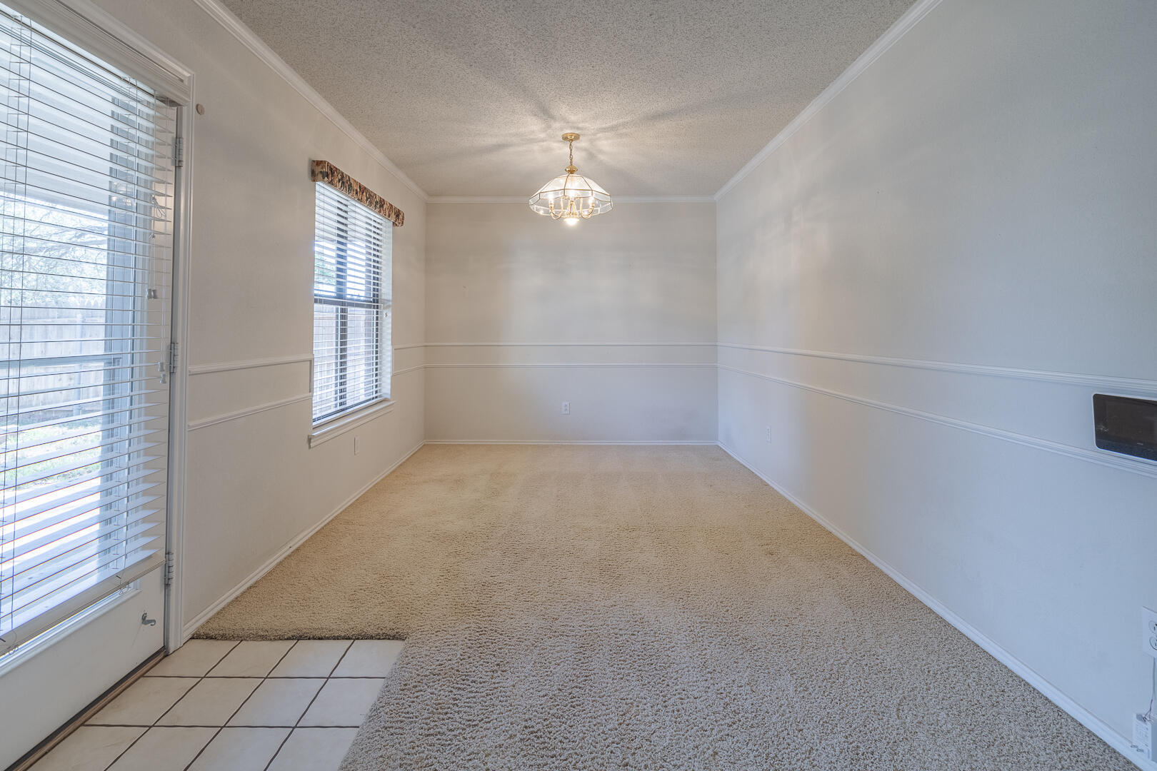 5415 68th Street Lubbock, TX 79424 - Photo 45 of 57 an empty room with windows and chandelier fan