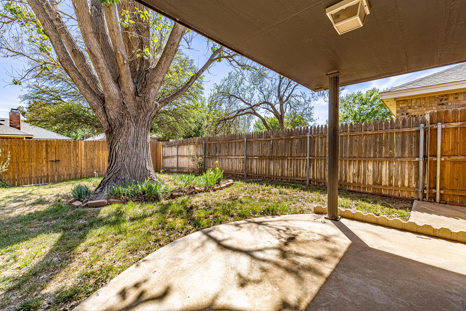 5415 68th Street Lubbock, TX 79424 - Photo 51 of 57 a view of backyard with wooden fence and a large tree