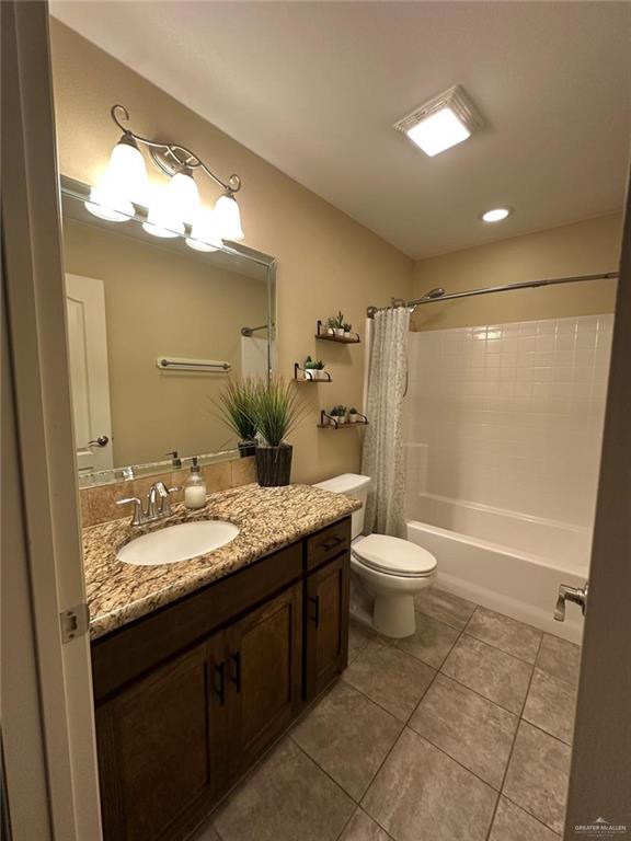 4608 Robin Avenue McAllen, TX 78504 - Photo 10 of 12 Bathroom featuring a vanity with a granite-style countertop, a white oval sink, and a mirrored wall