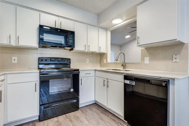 a kitchen with stainless steel appliances a stove microwave and sink