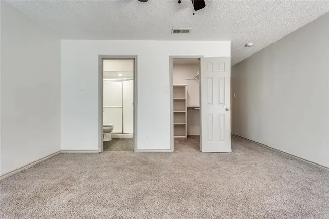 an empty room with closet and windows