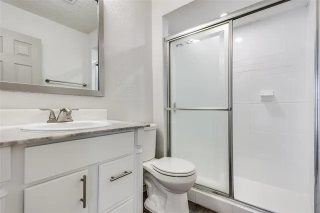 a bathroom with a granite countertop sink toilet and shower