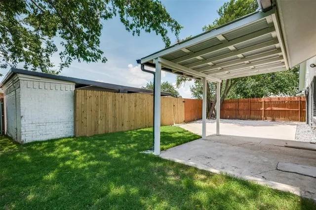 a backyard of a house with plants and outdoor seating