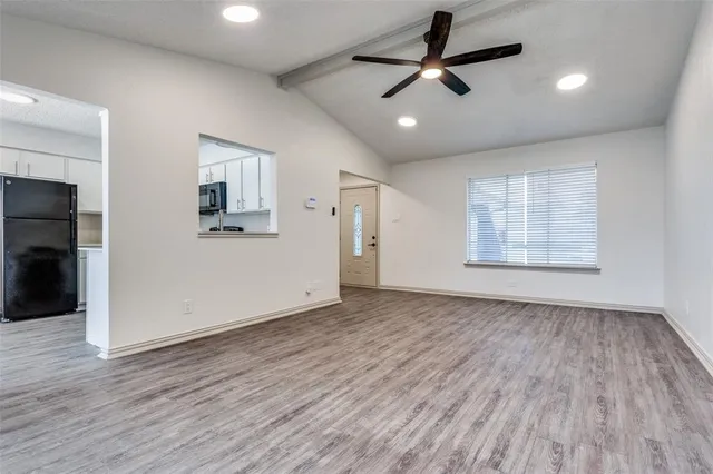 a view of empty room with wooden floor and ceiling fan