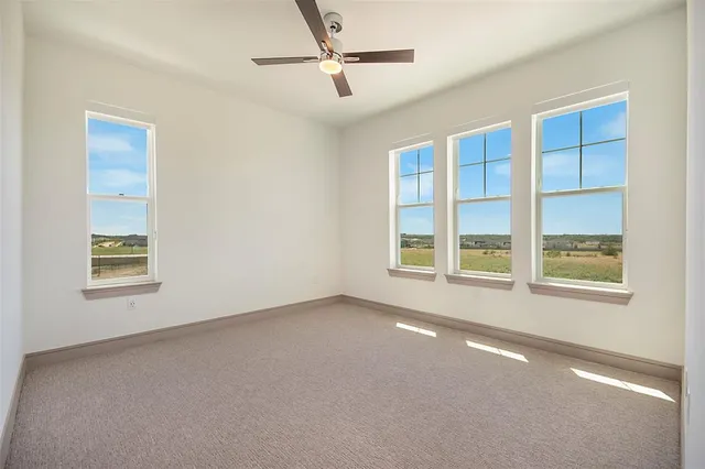 an empty room with a window and a ceiling fan