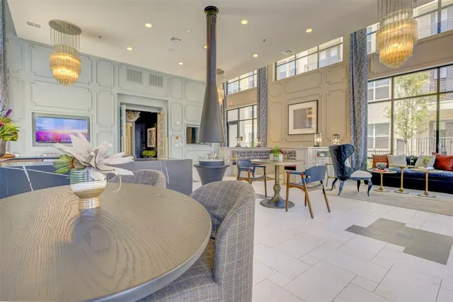 a living room with furniture a large window and kitchen view