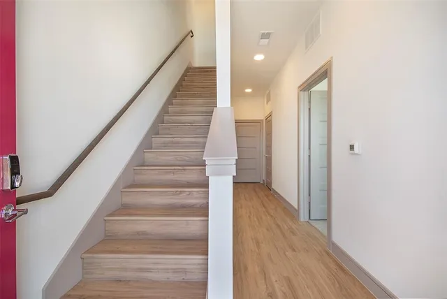 a view of staircase with wooden floor and white walls