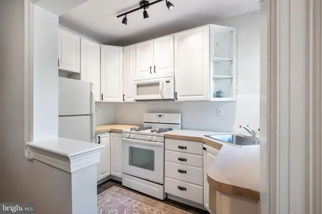 a kitchen with stainless steel appliances cabinets and wooden floor