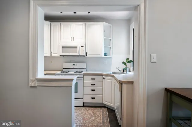 a kitchen with cabinets stainless steel appliances a sink and a window