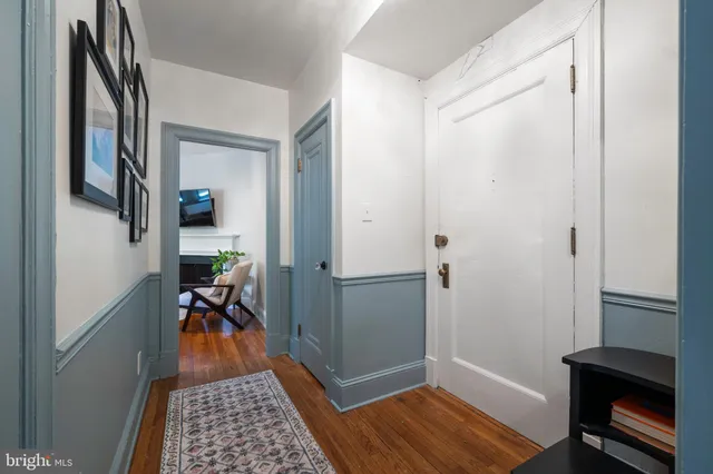 a hallway view with furniture and wooden floor