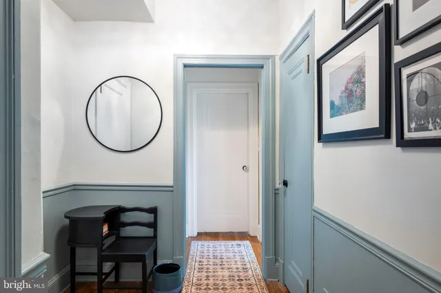 a view of a hallway with wooden floor and a dining room