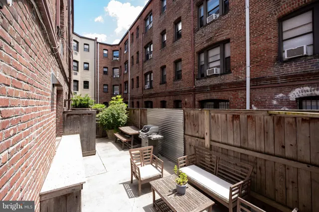 a view of a chairs and tables in the back yard of a building