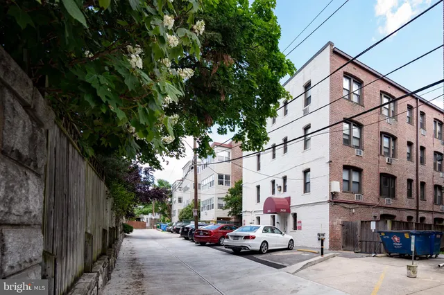 a view of a house with a barbeque and wooden fence