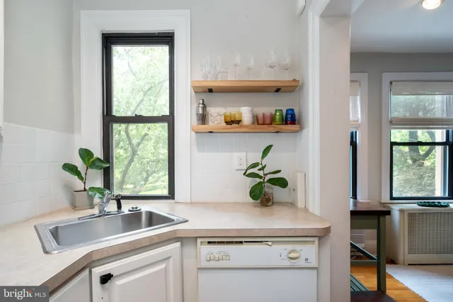 a kitchen with a refrigerator a sink and white cabinets