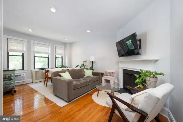 a living room with furniture a fireplace and a flat screen tv