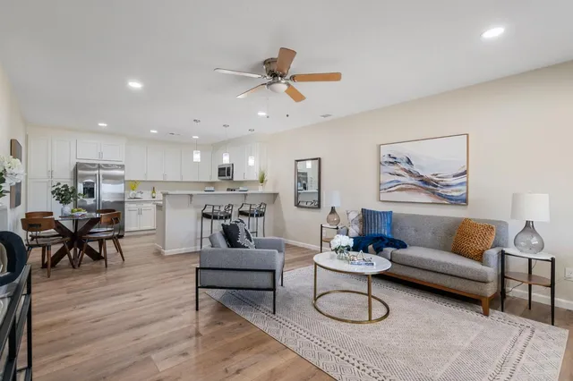 a living room with furniture kitchen view and a dining table
