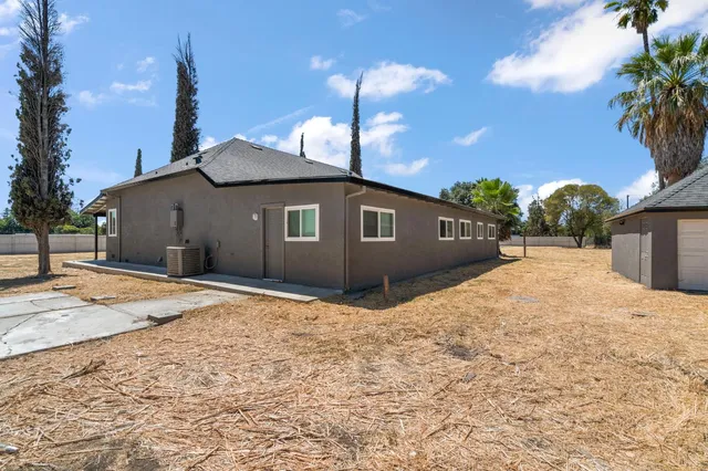an aerial view of a house with a yard and large trees