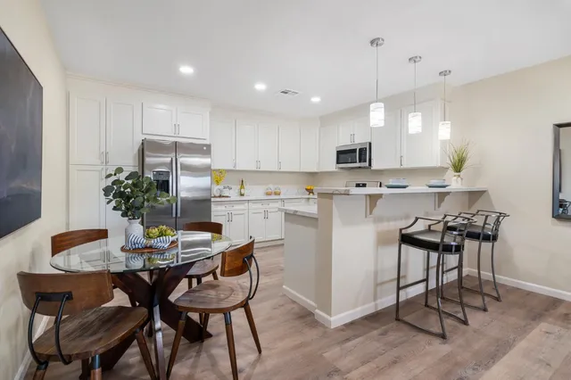 a kitchen with kitchen island a dining table and chairs