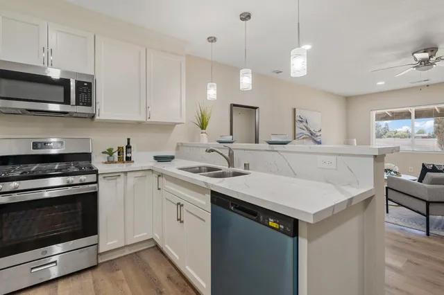 a kitchen with a sink a stove a microwave and cabinets