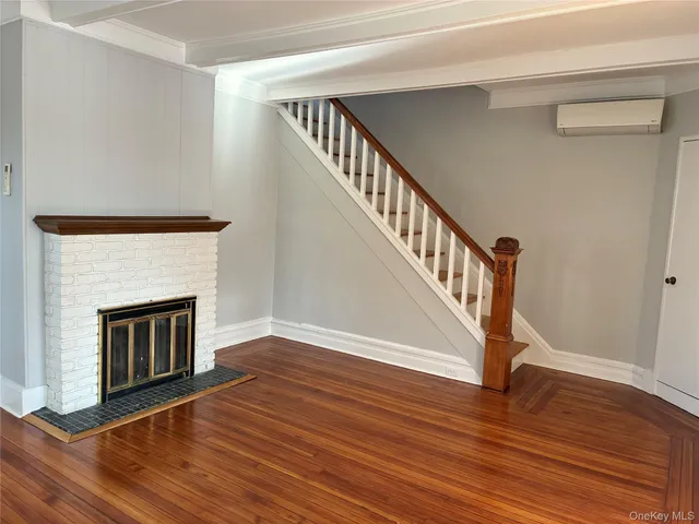 a view of a livingroom with wooden floor and a fireplace