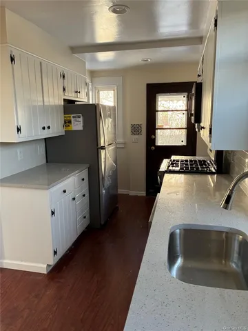 a kitchen with granite countertop a sink stove and refrigerator
