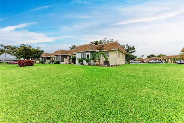 a view of a house with a big yard and large trees