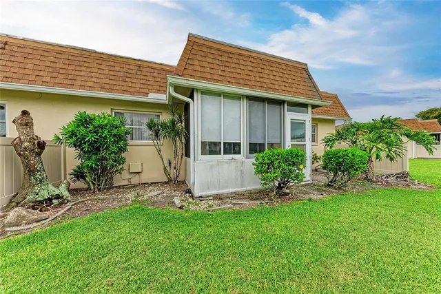 a front view of a house with a garden and plants