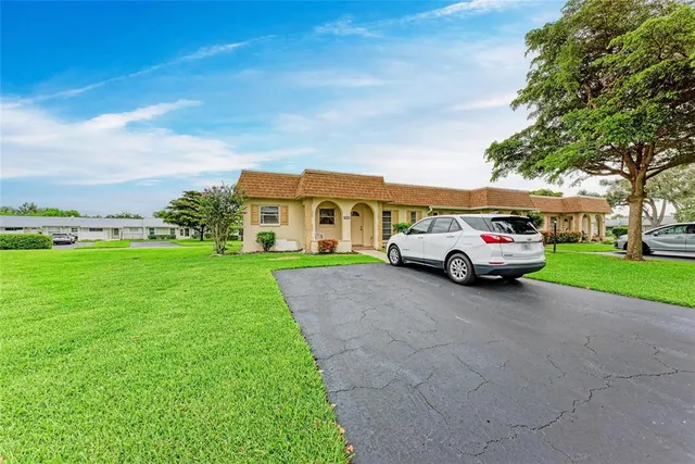 a car parked in front of a house with a yard