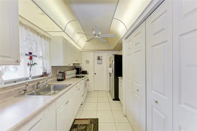 a large white kitchen with a sink and dishwasher a refrigerator with a sink