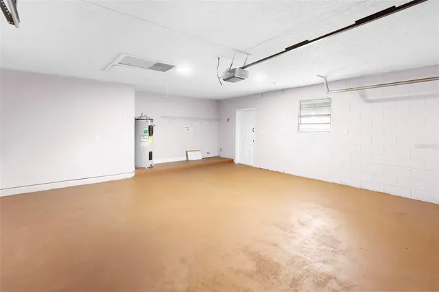 an empty room with ceiling fan and windows