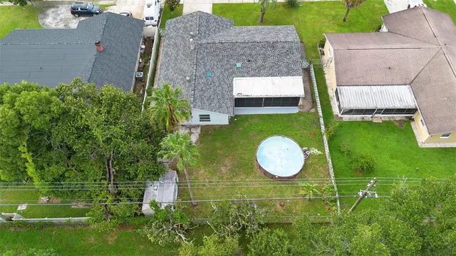 an aerial view of a house with swimming pool and garden