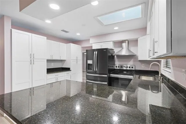 a kitchen with stainless steel appliances a stove a sink and a refrigerator