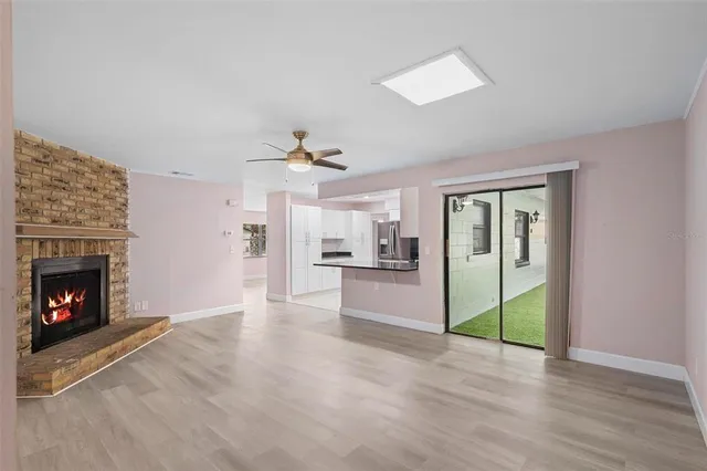a view of a livingroom with wooden floor a fireplace and window