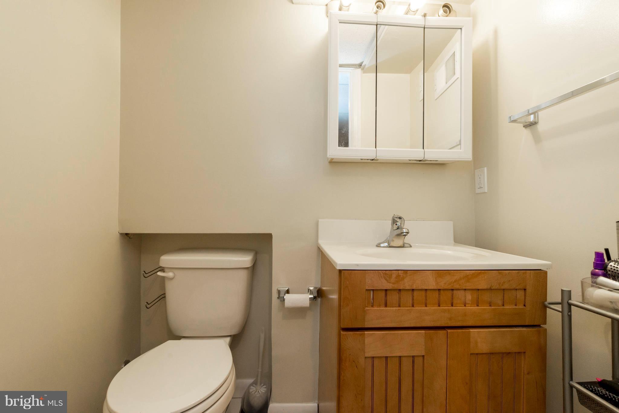 8528 Oakleigh Road Baltimore, MD 21234 - Photo 22 of 30 a bathroom with a toilet a sink and a window