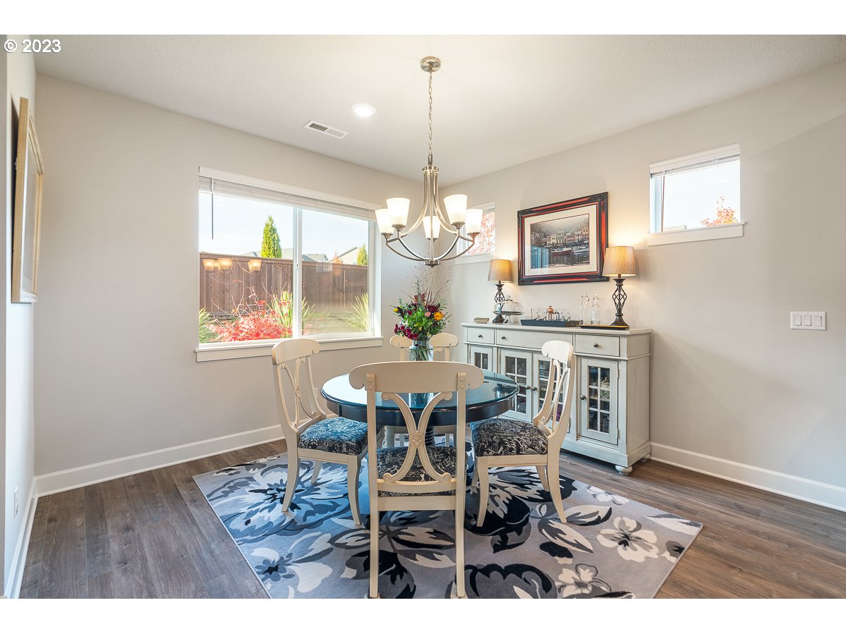 1819 South 50th Place Ridgefield, WA 98642 - Photo 7 of 48 a view of a dining room with furniture a chandelier and wooden floor