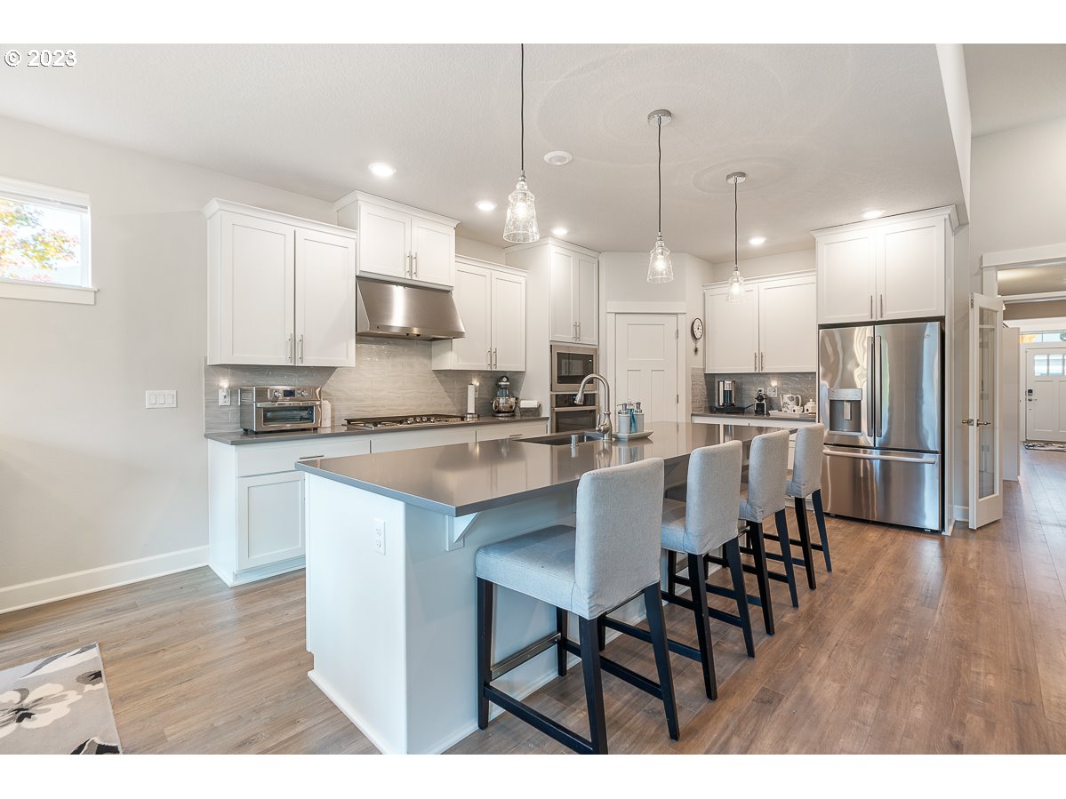 1819 South 50th Place Ridgefield, WA 98642 - Photo 8 of 48 a kitchen with stainless steel appliances kitchen island granite countertop a dining table chairs and sink