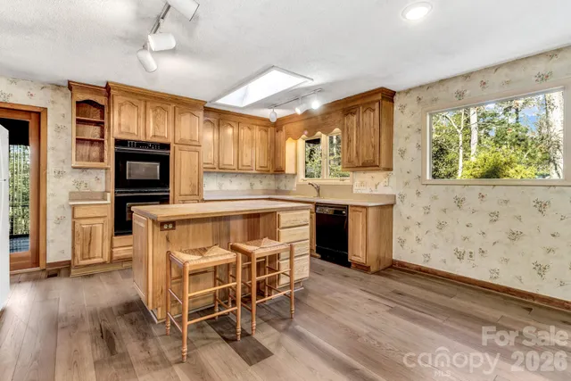 a view of empty room with wooden floor and fireplace