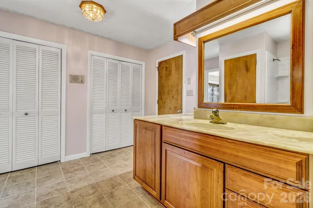 a view of an empty room with window and closet area