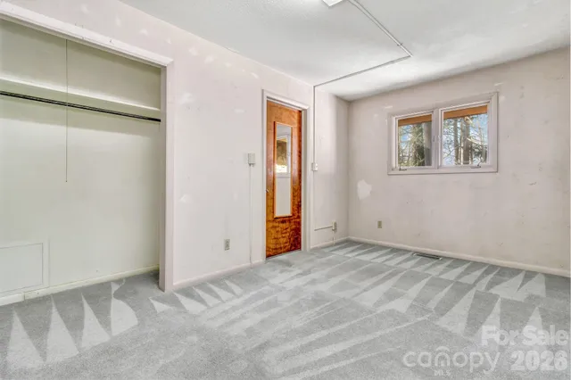 an empty room with closet and a window