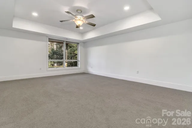 an empty room with a ceiling fan and a window