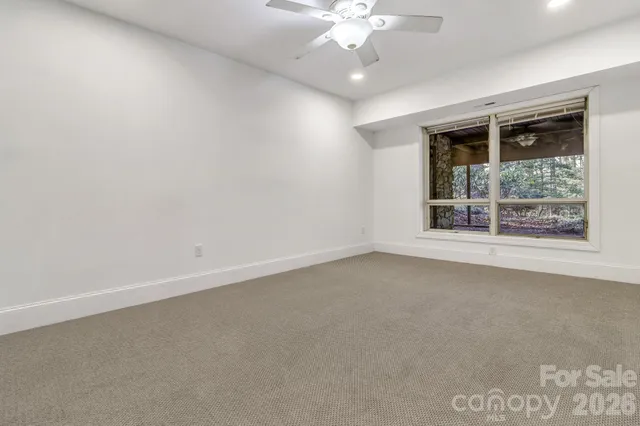 an empty room with a ceiling fan and a window