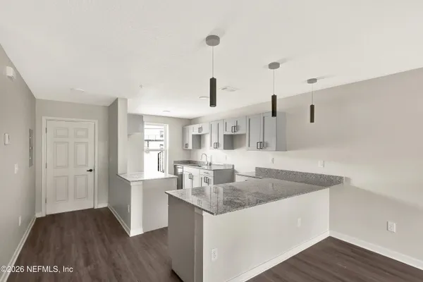 a kitchen with granite countertop a sink and dishwasher with wooden floor