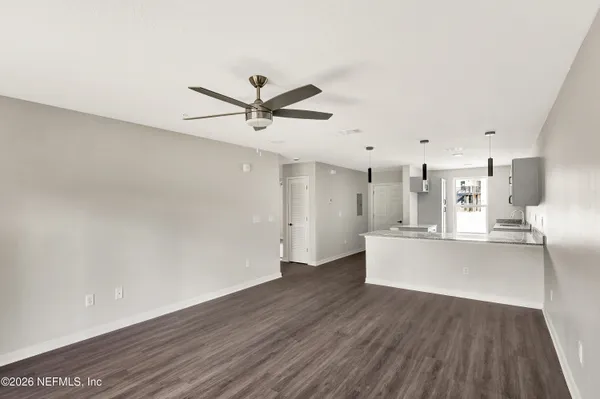 a view of kitchen with stainless steel appliances refrigerator stove and wooden floor