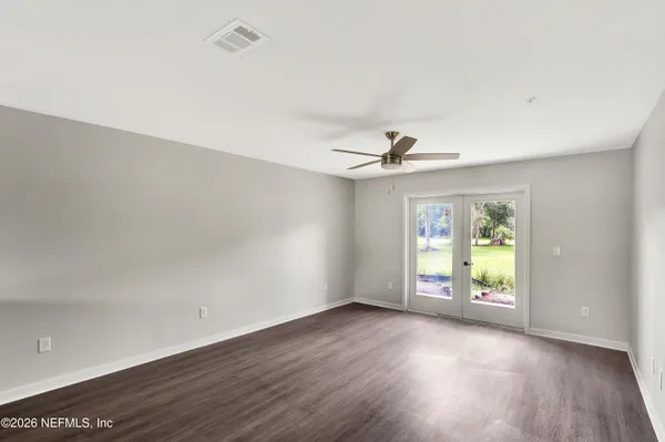 an empty room with wooden floor and windows