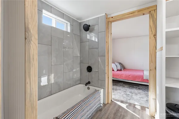 a bathroom with a tub shower and sink