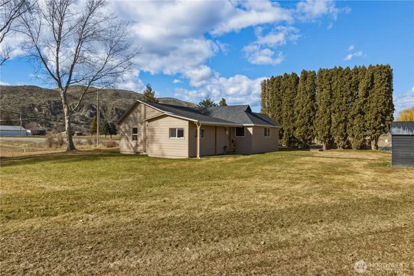 a view of a house with backyard and tree