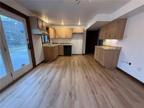 a kitchen with wooden floors and refrigerator